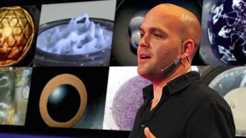 Seeper founder Evan Grant on stage at TEDGlobal 2009, cymatics images on the screen behind him