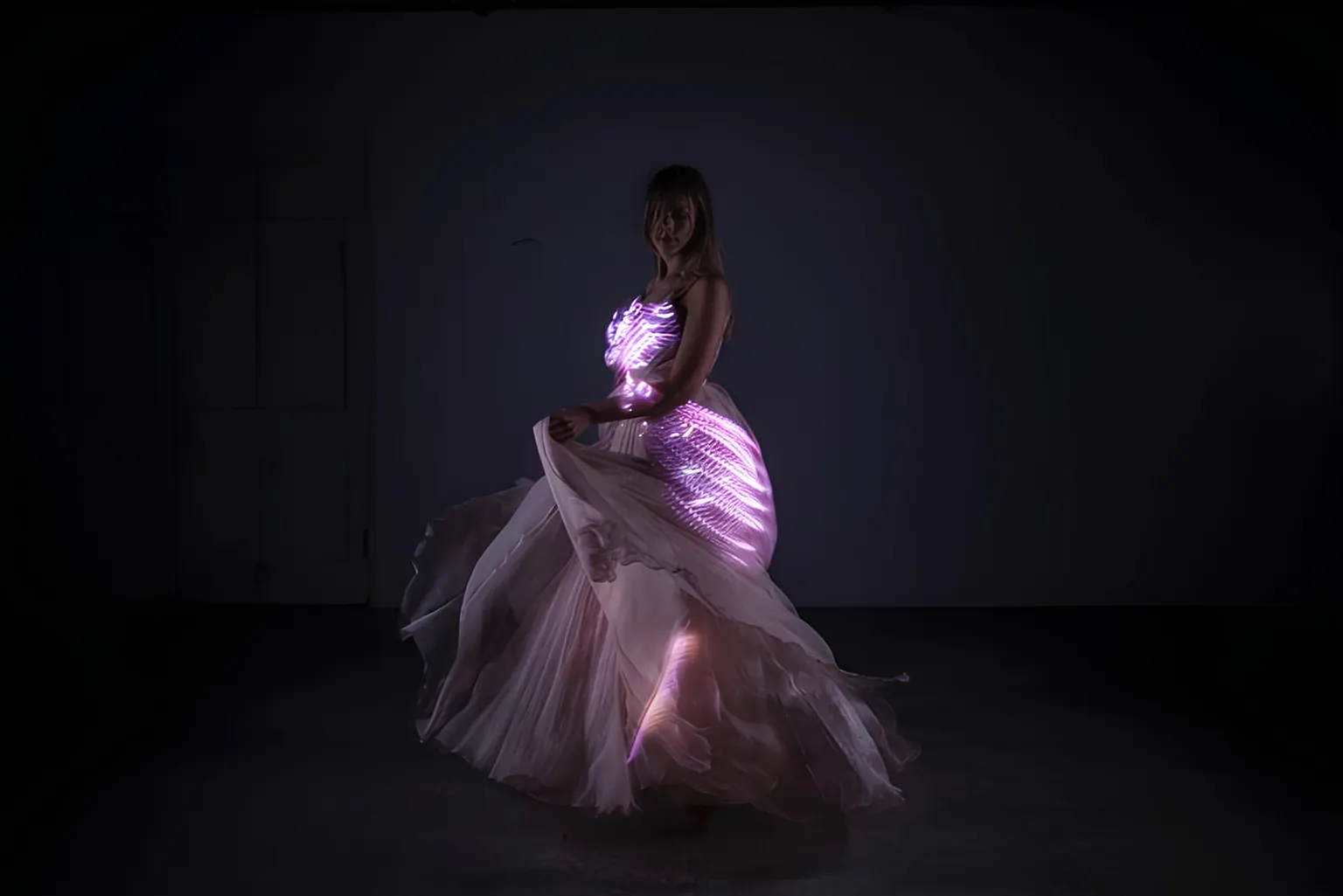 The finished LED dress glowing in pink and white light